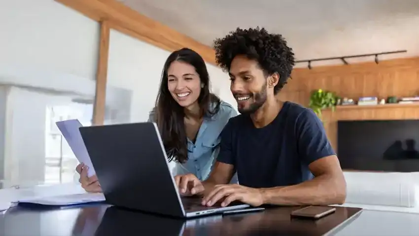 man and woman using laptops on a desk
